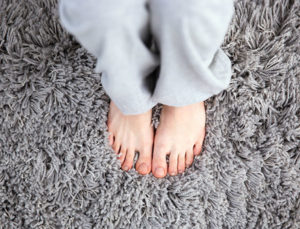 feet standing on a very clean grey carpet